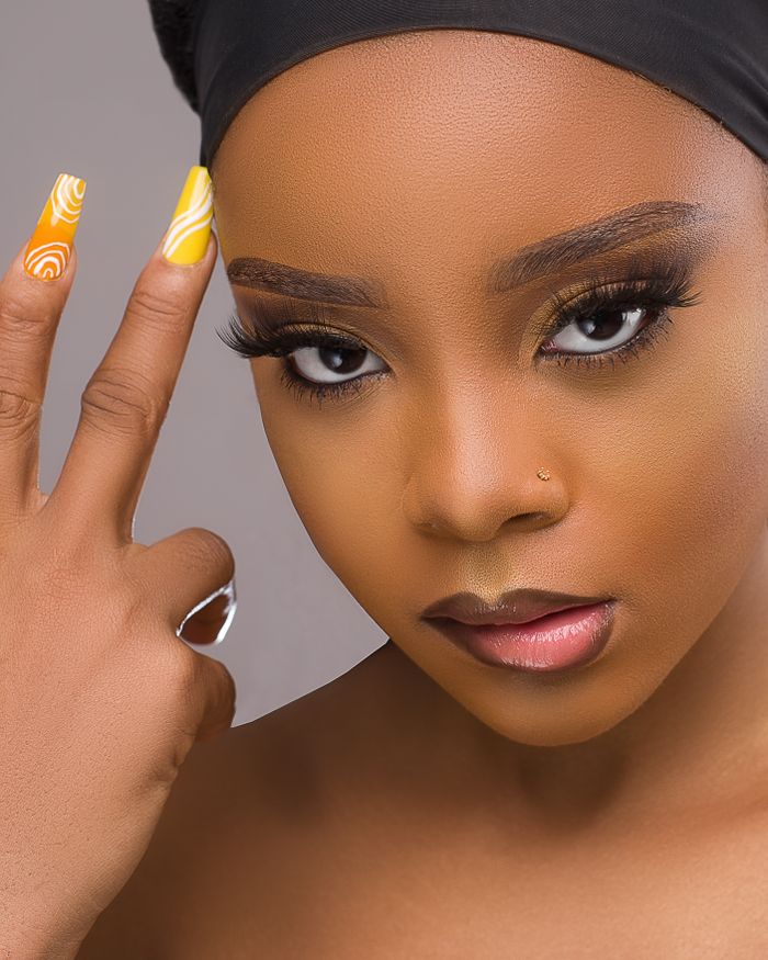 ours-journey Close-up portrait of a black woman with fierce expression and stylish nail art.